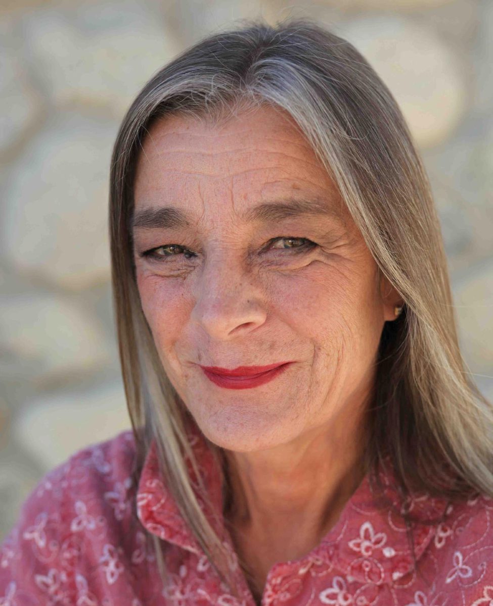 Smiling woman with gray hair and red lipstick.