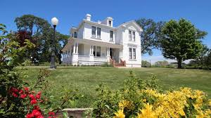 White Victorian house with flower gardens.
