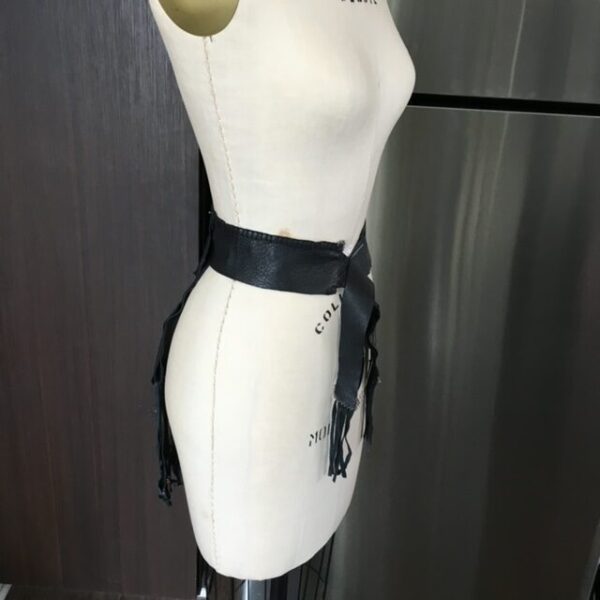 Black leather fringe belt on a mannequin.