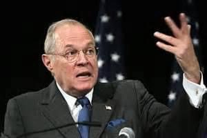 A man in a suit speaking at a podium.